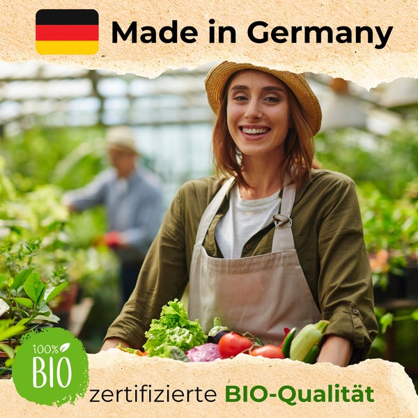 Lächelnde Gärtnerin im Gewächshaus mit frischem Bio-Gemüse. Hergestellt in Deutschland und 100 Prozent zertifizierte Bio-Qualität.