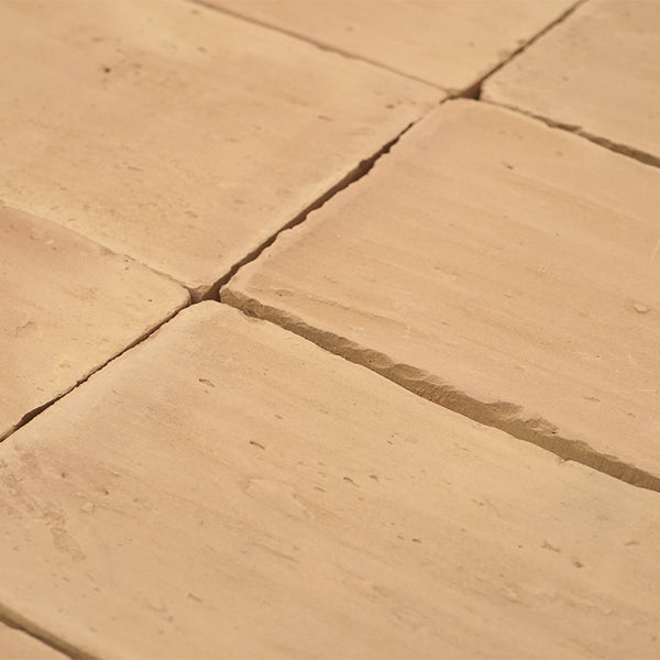 Nahaufnahme einer verlegten Naturstein Pflasteroberfläche mit unregelmäßigen Kanten und strukturierter Oberfläche.