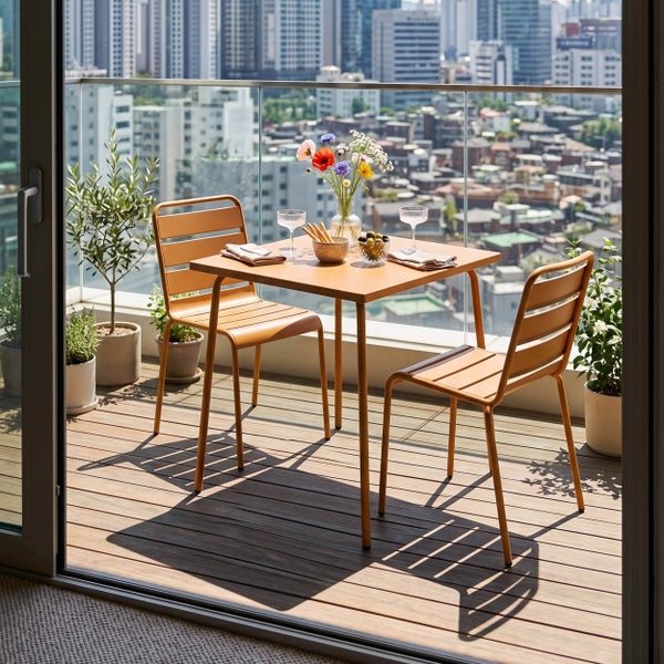 Modernes Bistro-Set mit quadratischem Tisch und zwei Metallstühlen auf einem Holzbalkon mit Stadtblick und Topfpflanzen.