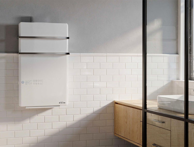 Elektrischer Handtuchwärmer im Badezimmer mit Fliesenwand und Waschtischunterschrank