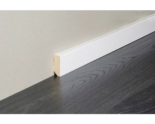 Weiße Sockelleiste an einer Wand über einem Boden mit Holzstruktur.