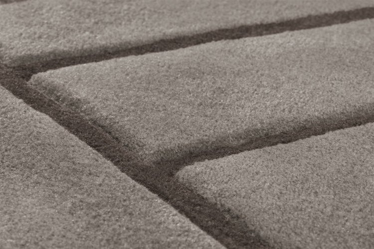 Nahaufnahme eines Teppichs mit geometrischem Linienmuster und strukturierter Oberfläche