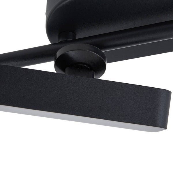 Detailaufnahme des schwarzen Metallgelenks einer Wandleuchte oder Deckenleuchte.