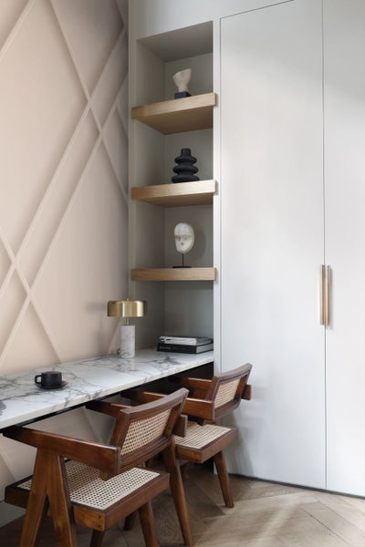 Helles Arbeitszimmer mit Marmorplatte, Regalen und Holzstühlen