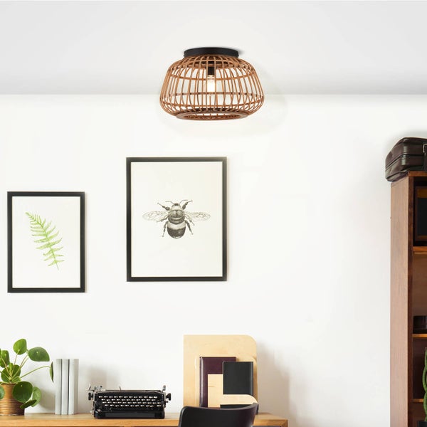 Deckenleuchte aus Bambusgeflecht in einem hellen Arbeitszimmer mit Schreibtisch, Schreibmaschine und gerahmten Bildern.