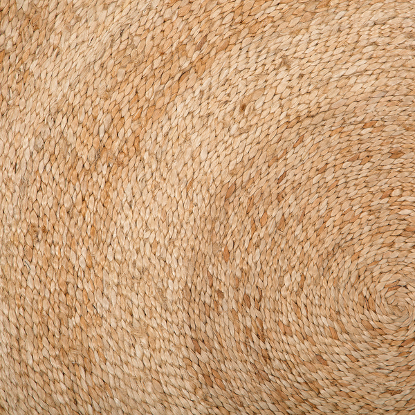 Detailansicht eines Teppichs aus geflochtener Naturfaser mit spiralförmiger Struktur.