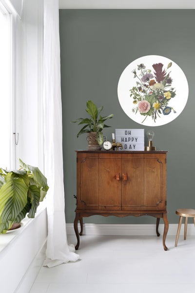 Dekorative Szene mit Kommode, Pflanzen und runder Blumendekoration