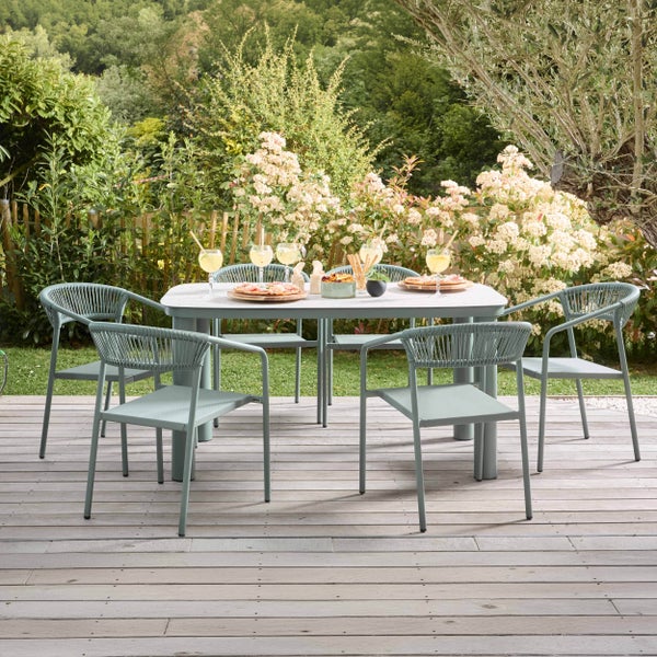 Modernes Gartenmöbel-Set mit Esstisch und sechs Stühlen mit Seilgeflecht auf einem Holzdeck vor einem dicht bepflanzten Garten.