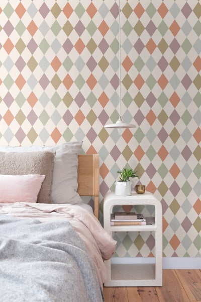 Schlafzimmer mit Bett, Nachttisch und Tapete mit Rautenmuster