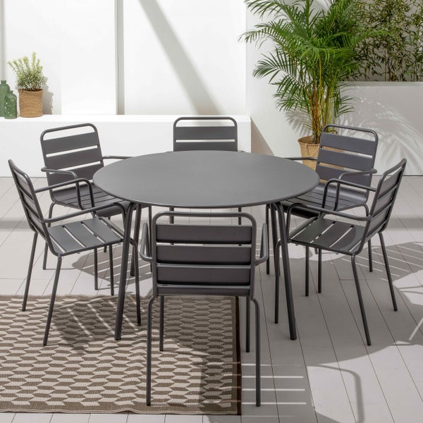 Moderne Gartenmöbel-Gruppe bestehend aus einem runden Metalltisch und sechs Stühlen auf einer hellen und organisierten Terrasse mit Pflanzen.