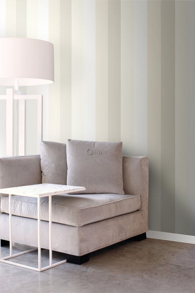 Wohnzimmer mit gestreifter Tapete, Sessel, Beistelltisch und Stehlampe