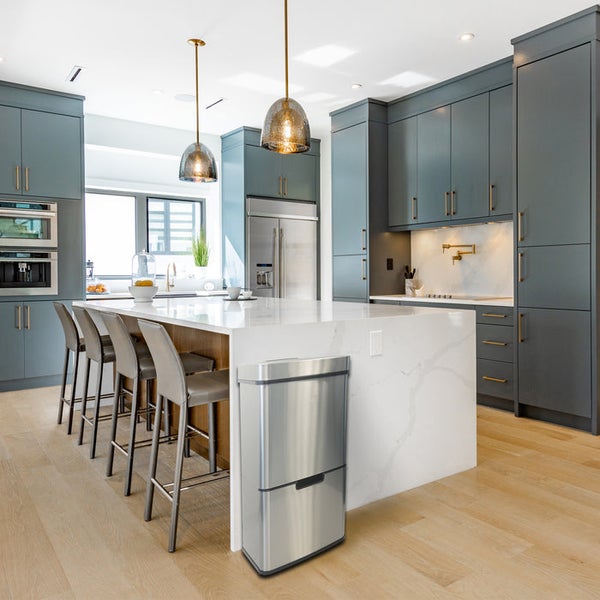 Helle Küche mit Kochinsel, Barhockern und einem Mülleimer aus Edelstahl