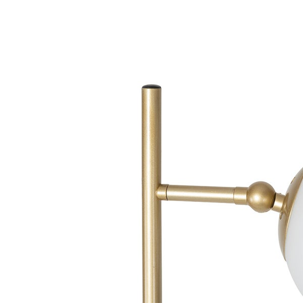 Detailansicht einer goldenen Stehlampe mit einem weißen Glasschirm.