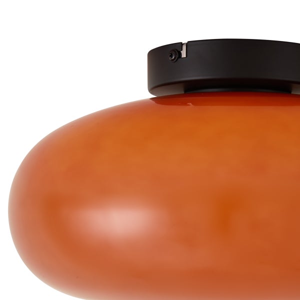 Nahaufnahme einer Deckenleuchte mit orangefarbenem Glasschirm und schwarzer Metallhalterung.