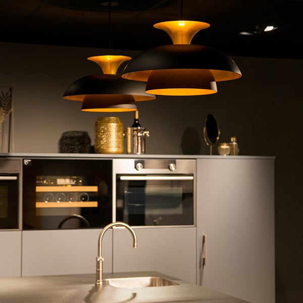 Drei Hängelampen über einer Küchenzeile mit Spüle und Geräten