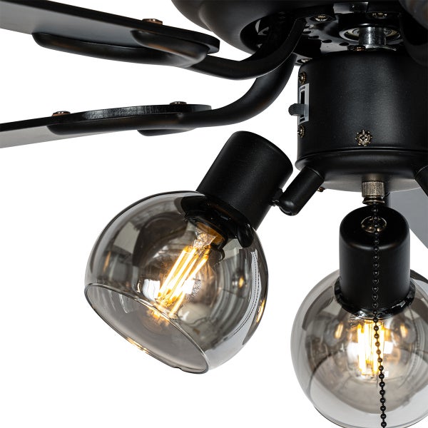 Nahaufnahme eines schwarzen Deckenventilators mit rauchigen Glaskugeln, leuchtenden LED-Filament-Lampen und einer Zugkette.