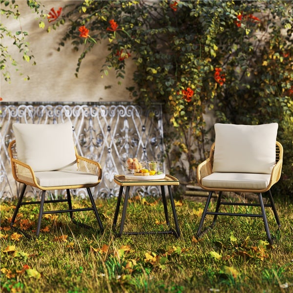 Gartenszene mit zwei Rattanstühlen, einem Beistelltisch und dekorativen Elementen im Freien