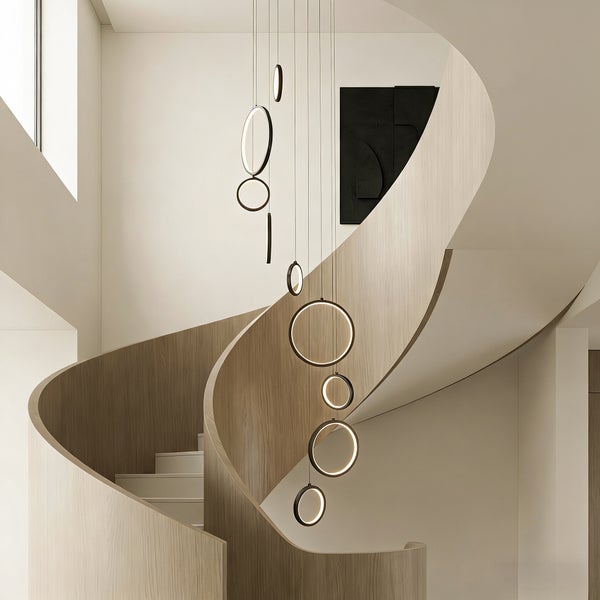 Innenaufnahme eines Treppenhauses mit Wendeltreppe und runden Hängeleuchten
