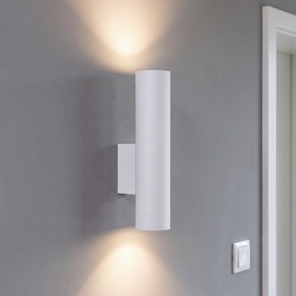 Moderne zylindrische Wandleuchte mit Up and Down Lichtkegel an einer grauen Wand