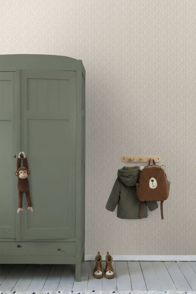 Kinderzimmer mit gemusterter Tapete, grünem Kleiderschrank aus Holz, einer Garderobe mit Kinderjacke und Bärenrucksack sowie Kinderschuhen.