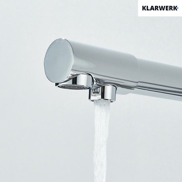 Klarwerk Logo. Nahaufnahme eines Armaturenauslaufs aus Metall mit zwei Strahlreglern, aus dem ein Wasserstrahl fließt.
