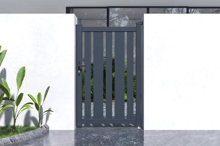 Modernes Gartentor aus Metall in Anthrazit mit vertikalen Lamellen, montiert zwischen zwei Wänden in einem hellen Außenbereich.