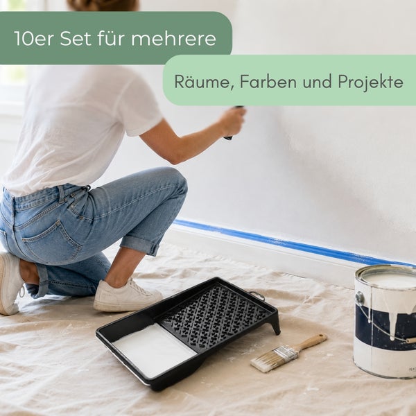 Person beim Streichen einer Wand, im Vordergrund Farbwanne, Pinsel und Farbeimer auf Abdeckvlies. Set von zehn für mehrere Räume und Projekte.
