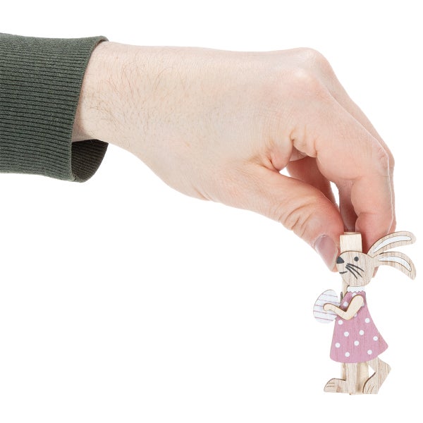 Eine Hand hält eine dekorative Holzklammer in Form eines Osterhasen mit Kleid und Ei zur Veranschaulichung der Größe.