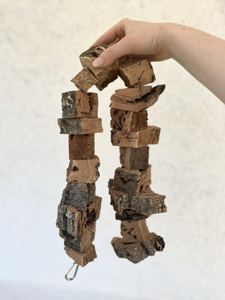 Vogelspielzeug aus Naturkork zum Aufhängen, bestehend aus verschiedenen Korkstücken und Rindenstücken.