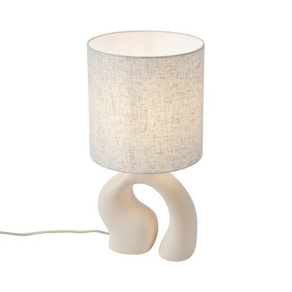 Tischleuchte mit skulpturalem Keramikfuß und zylindrischem Textilschirm.