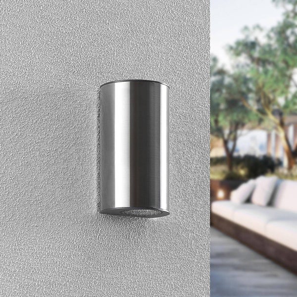 Zylindrische Außenwandleuchte aus gebürstetem Edelstahl an einer verputzten Wand.