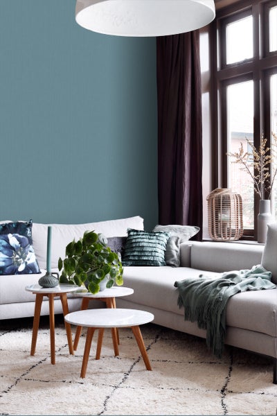 Wohnzimmer mit Sofa, Kissen, Tisch und Teppich für eine gemütliche Atmosphäre