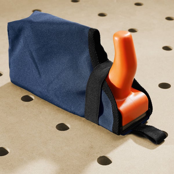 Stanley Surform Hobel mit blauem Textil-Spänefangbeutel auf einer Werkbank mit Lochraster.