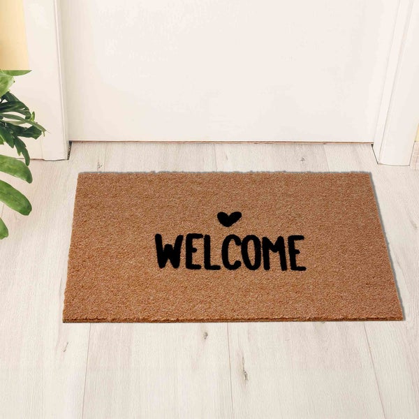 Fußmatte mit der Aufschrift Willkommen und einem Herzsymbol vor einer Tür