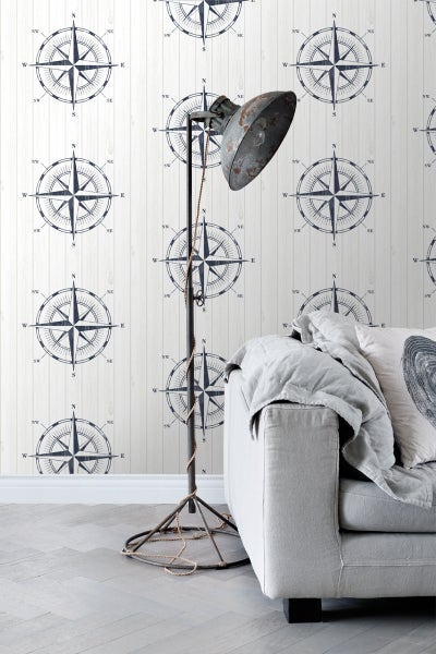 Wohnraum mit Kompass-Tapete, Stehlampe und Sofa