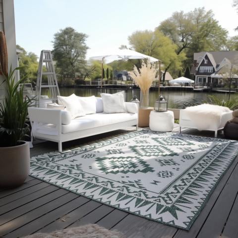 Außenbereich mit weißem Sofa, Teppich mit Muster und Blick auf den See