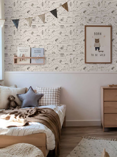 Kinderzimmer mit einer Kindertapete mit Straßenmotiv, Autos und Häusern, ergänzt durch ein Wandregal mit Büchern und ein Bärenposter.