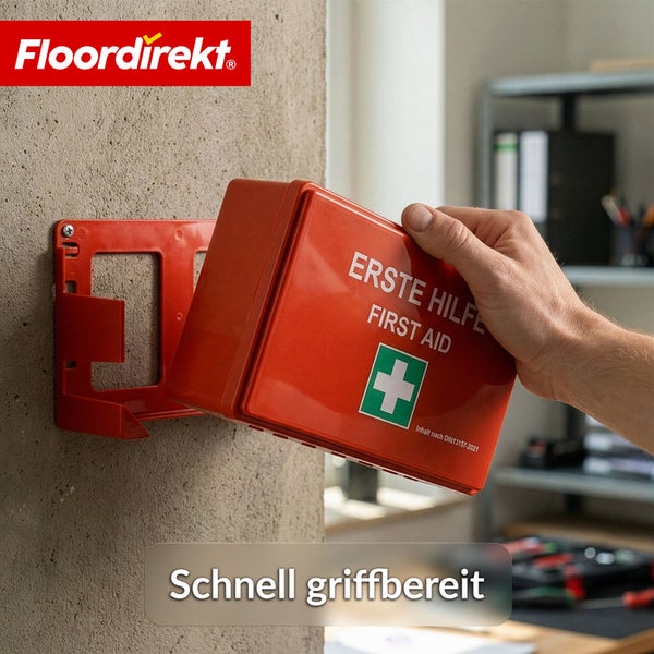 Hand entnimmt einen Erste-Hilfe-Koffer nach DIN 13157 mit Floordirekt Logo aus einer Wandhalterung.