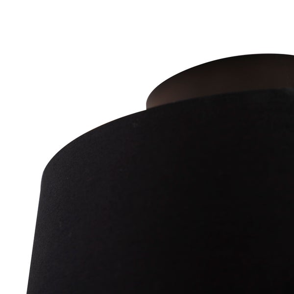 Nahaufnahme eines runden Lampenschirms aus schwarzem Textilgewebe.