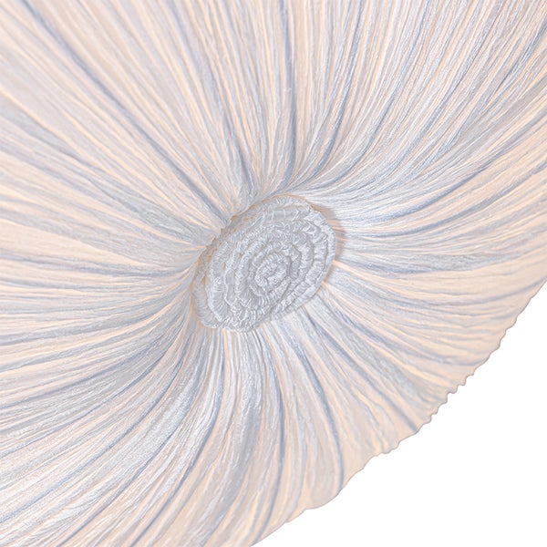 Nahaufnahme eines weißen Lampenschirms aus plissiertem Stoff mit radialem Muster.