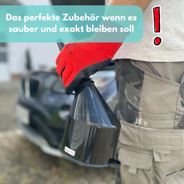 Mann hält einen schwarzen Trichter vor einem Auto.