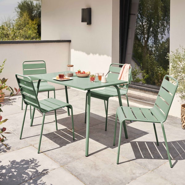 Modernes Gartenmöbel-Set aus Metall mit einem rechteckigen Tisch und vier Stühlen auf einer gepflasterten Terrasse.