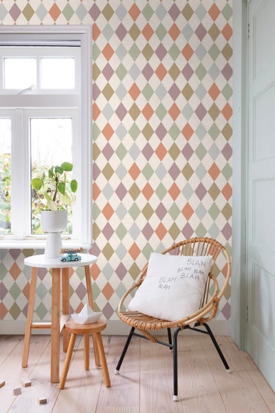 Zimmer mit Rautenmuster-Tapete, Rattansessel und Beistelltisch