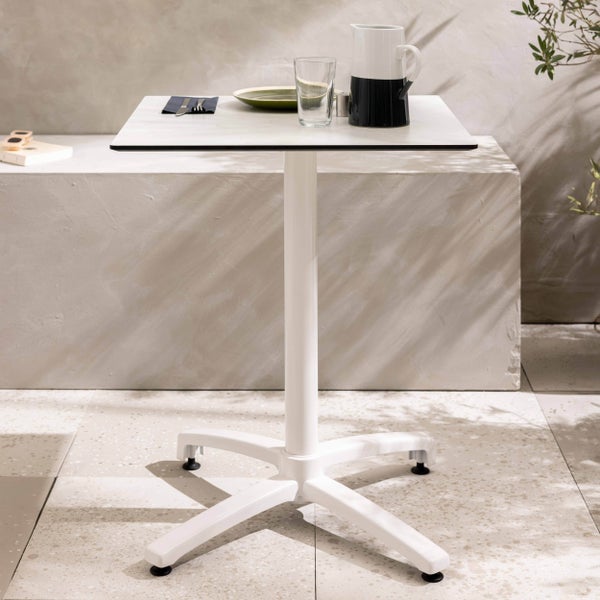 Moderner quadratischer Bistrotisch mit Mittelfuß und vierteiligem Fußkreuz auf einer hellen Terrasse mit Geschirr gedeckt.