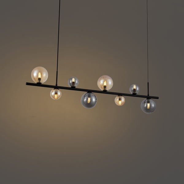 Moderne Pendelleuchte mit sieben Glaskugeln an einer schwarzen Stange