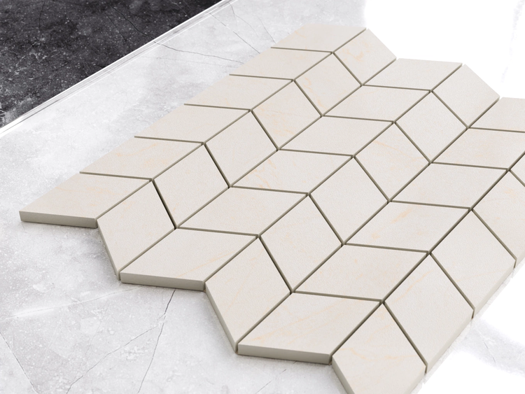 Mosaikfliesen in Rautenform, Chevron-Muster, beige Marmor-Optik.