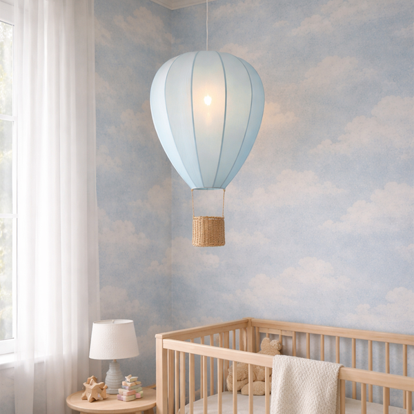 Pendelleuchte in Heißluftballon-Form mit Weidenkorb in einem Kinderzimmer mit Wolkentapete und Holz-Gitterbett.