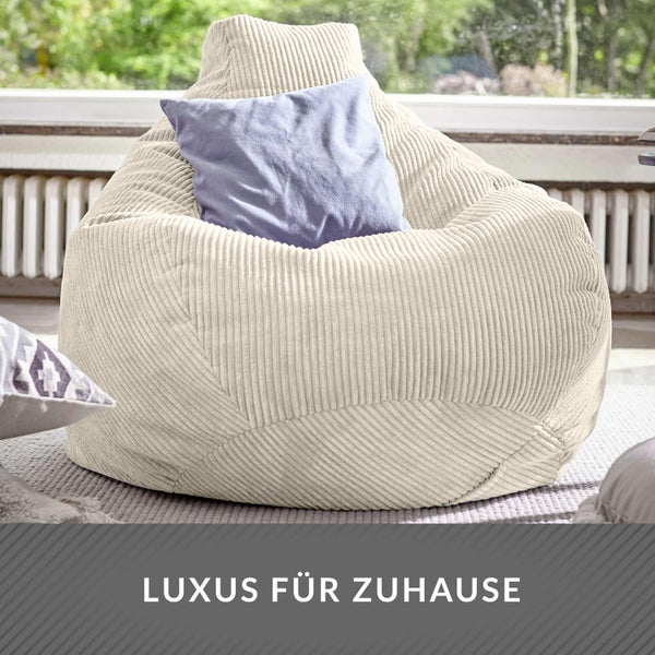 Szene mit einem Cord-Sitzsack auf einem Balkon neben einem Tisch mit Dekorationen und einem Kissen.