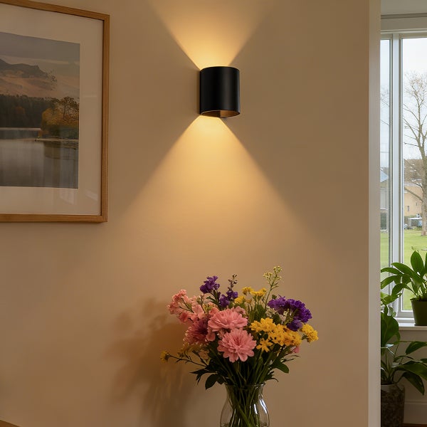 Wandleuchte aus Metall mit Lichtkegel, Dekoration mit Blumen und gerahmtem Bild