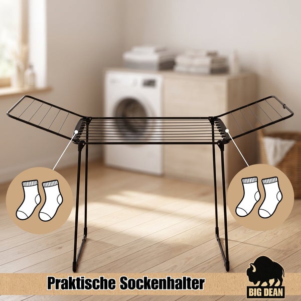 Wäscheständer aus Metall mit ausklappbaren Flügeln und integrierten Sockenhaltern vor einer Waschmaschine.